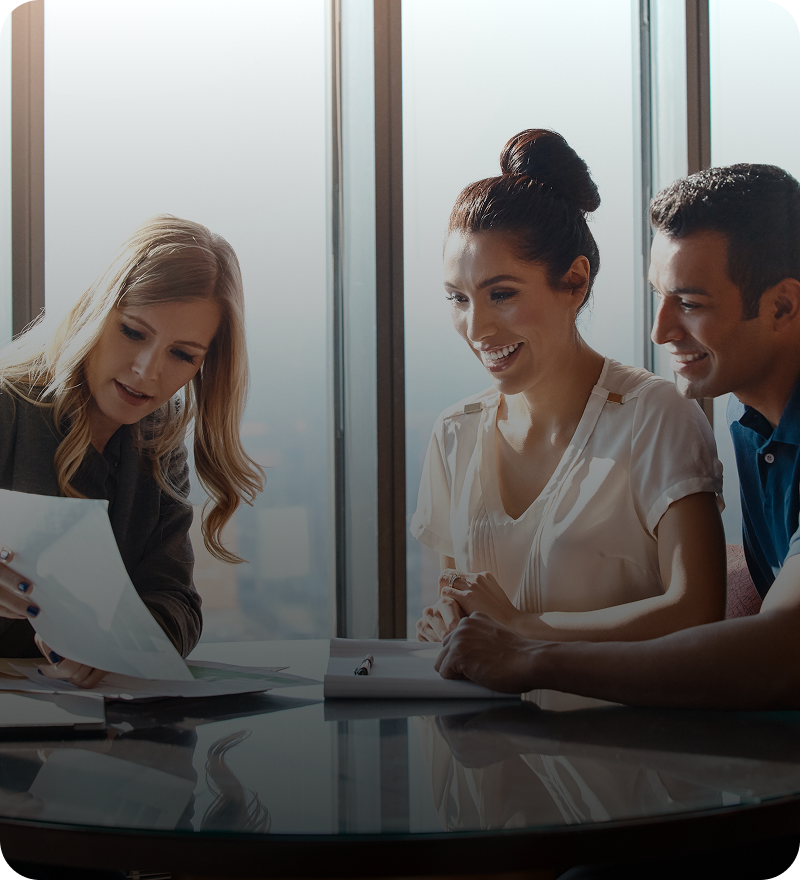 People reviewing documents at an office table.
